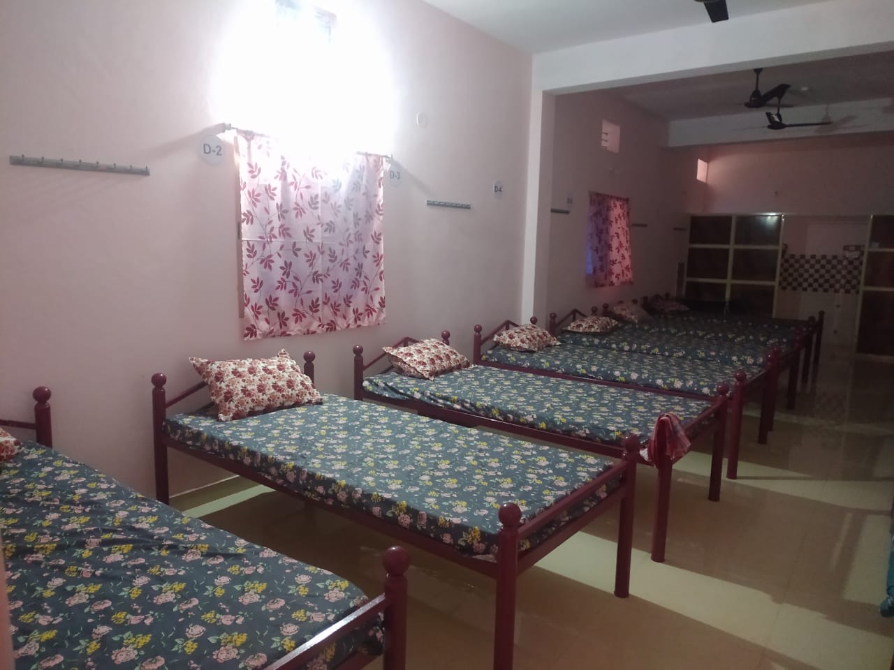 Dormitory hall at Bhakta Niwas with several single beds, ideal for groups and yatra parties
