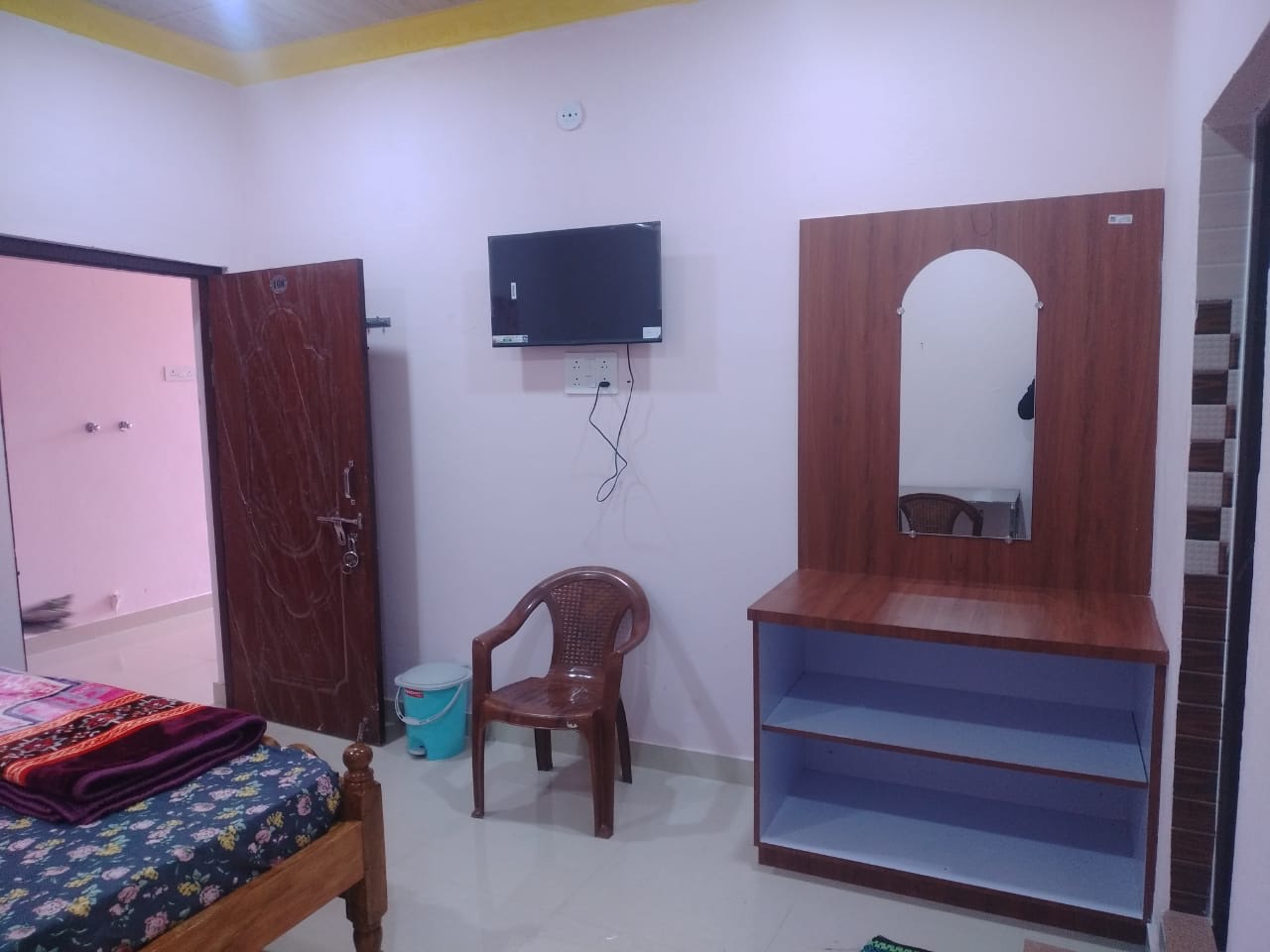 Private room at Bhakta Niwas with a double bed, wall-mounted TV and dressing table
